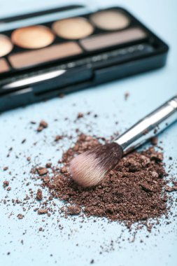 Renk arkaplanında makyaj fırçası ve gevşek göz farı