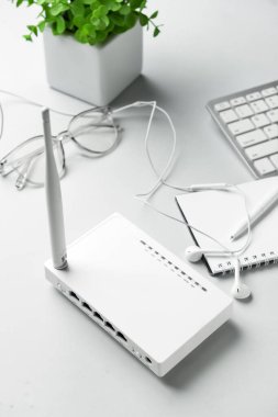 Wi-Fi yönlendirici, kulaklık ve arka planda not defteri.