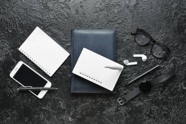 Wi-Fi yönlendirici, akıllı telefon ve koyu arkaplanda kırtasiye malzemesi