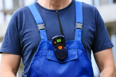 İnşaat alanında radyo vericili bir erkek işçi.