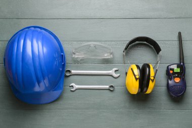 Ahşap arka planda inşaat aletleri ve radyo vericisi olan güvenlik ekipmanları