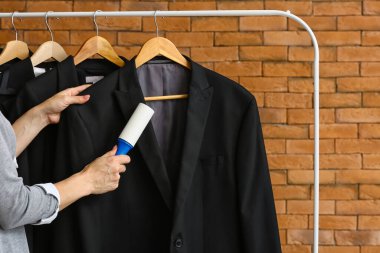 Tuğla duvarın yanında pamuklu silindirli kadın ceketi.