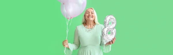 テキストのためのスペースと緑の背景に気球を保持する笑顔成熟した女性 国際女性デーのお祝い — ストック写真