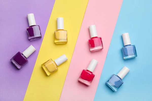 Set of nail polish bottles on color background