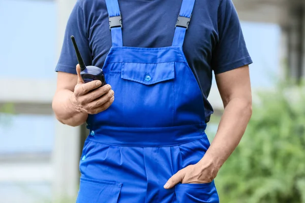 İnşaat alanında radyo vericili bir erkek işçi.