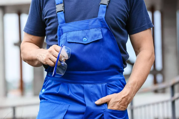 İnşaat alanında koruyucu gözlüklü erkek işçi.