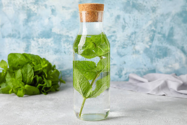 Bottle of water with mint on table