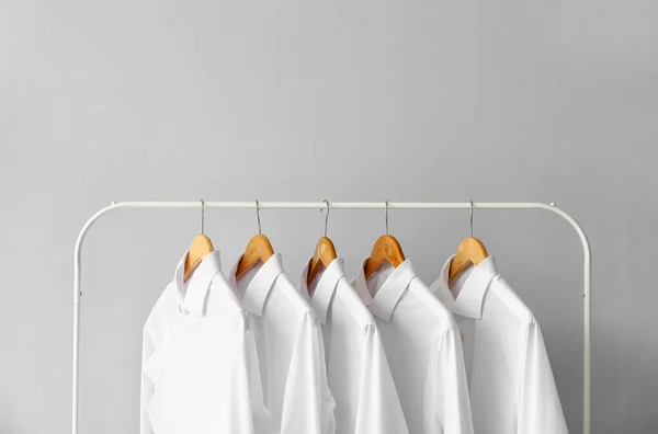 Bastidor Con Camisas Limpias Sobre Fondo Gris —  Fotos de Stock