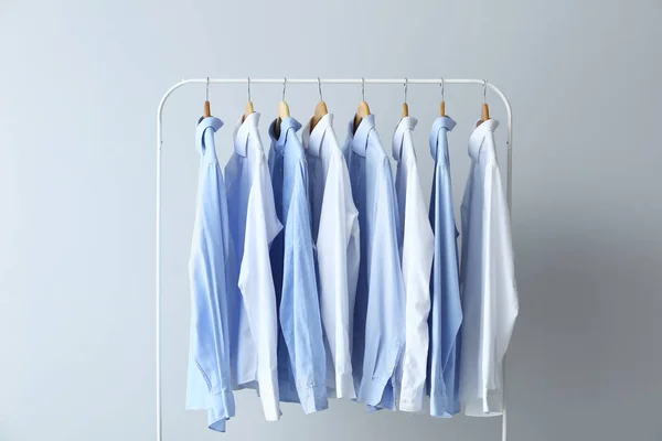 Bastidor Con Camisas Limpias Sobre Fondo Gris —  Fotos de Stock