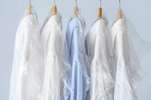 Rack Met Schone Shirts Plastic Zakken Grijze Achtergrond — Stockfoto