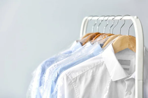 Rack Clean Shirts Plastic Bags Grey Background — Stock Photo, Image