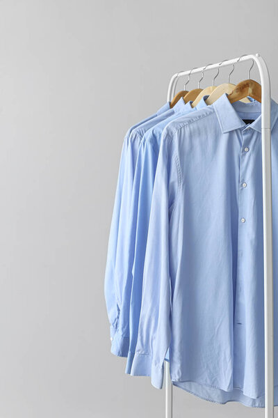 Rack with clean shirts on grey background