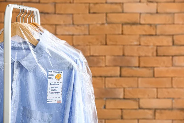 Rack Clean Shirts Plastic Bags Brick Wall — Stock Photo, Image