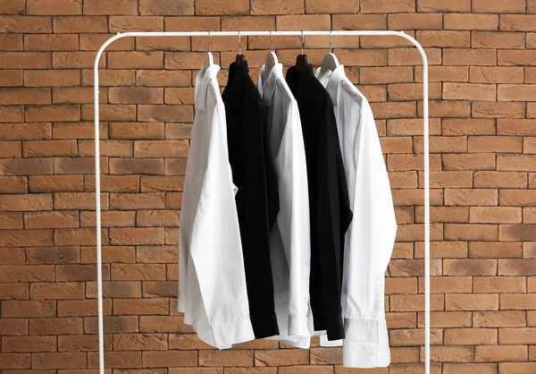 Rack Met Schone Shirts Buurt Van Bakstenen Muur — Stockfoto