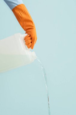Adam plastik kutudan renk arkaplanına sıvı döküyor