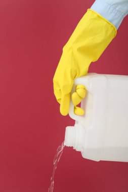 Adam plastik kutudan renk arkaplanına sıvı döküyor