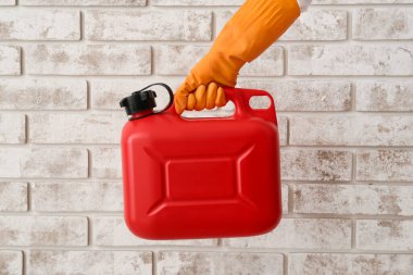 Lastik eldivenli bir erkek, tuğla duvarın yanında bir kutu tutuyor.