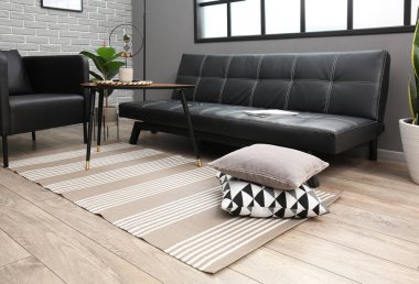 Gri tuğla duvarın yanındaki modern mobilyalarla oturma odasının içinde.