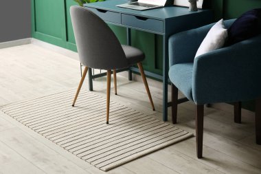 Renkli duvarın yanında rahat koltuğu ve modern çalışma yeri olan bir oda.