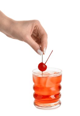 Beyaz arka planda bir bardak Manhattan kokteyli olan kadın.