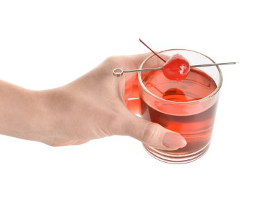 Beyaz arka planda vişneli Manhattan kokteyli bardağı tutan kadın.