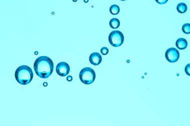 Mavi zemin üzerinde hava kabarcıkları olan temiz su