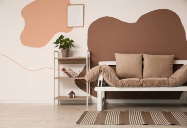 Oturma odasının içinde kanepe ve raf ünitesi var.