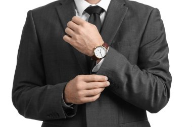 Resmi takım elbiseli yakışıklı adam beyaz arka planda kollarını ayarlıyor, yakın plan.