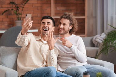 Mutlu nişanlı eşcinsel çift evde selfie çekiyor.
