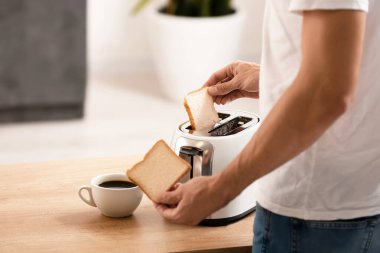 Genç adam mutfakta lezzetli tost yapıyor, yakın plan.