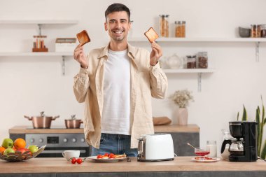 Genç adam mutfakta lezzetli tost yapıyor.