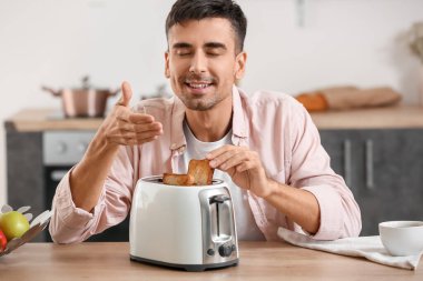 Genç adam mutfakta lezzetli tost yapıyor.