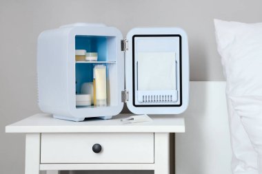 Yatak odasındaki küçük kozmetik buzdolabı.