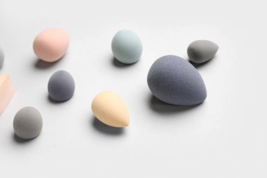 Açık arkaplanda farklı makyaj süngerleri, yakın plan