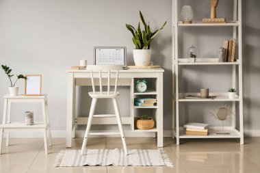 Modern işyeri, dizüstü bilgisayar ve raf üniteli aydınlatma odasının içi