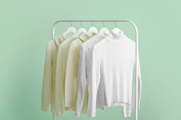 Rack Dengan Sweater Putih Bersih Latar Belakang Hijau — Stok Foto