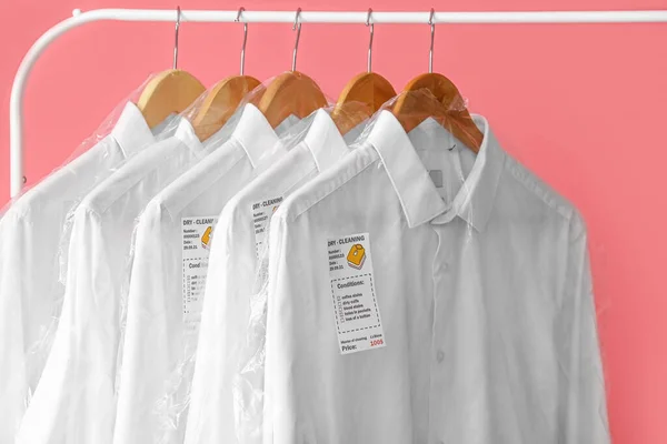Cremalheira Com Camisas Brancas Limpas Sacos Plástico Sobre Fundo Rosa — Fotografia de Stock