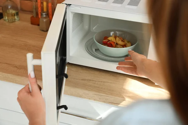 Wanita Muda Mengambil Mangkuk Dengan Makanan Lezat Dari Oven Microwave — Stok Foto