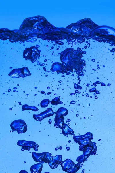 青い背景に気泡のあるきれいな水 — ストック写真