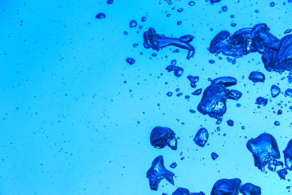 青い背景に気泡のあるきれいな水 — ストック写真