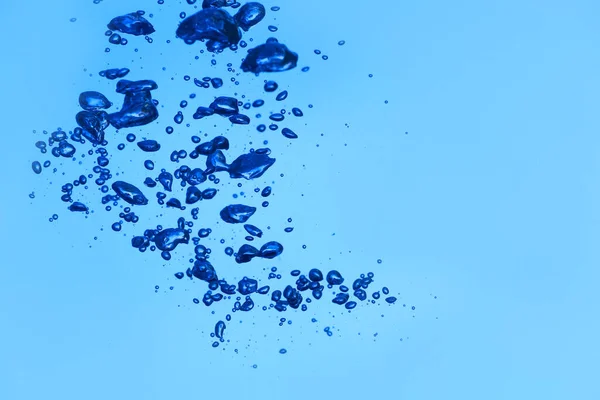 Przezroczysta Woda Pęcherzykami Powietrza Niebieskim Tle — Zdjęcie stockowe