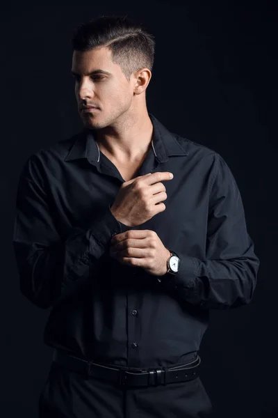 Fashionable Gentleman Adjusting Sleeve Looking Aside Dark Background — Stock Photo, Image