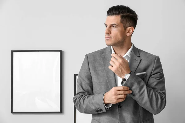 Handsome Man Elegant Suit Adjusting Sleeve Grey Wall — Stock Photo, Image