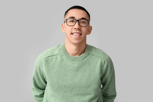 身穿灰色背景针织毛衣的英俊年轻亚洲男子 — 图库照片