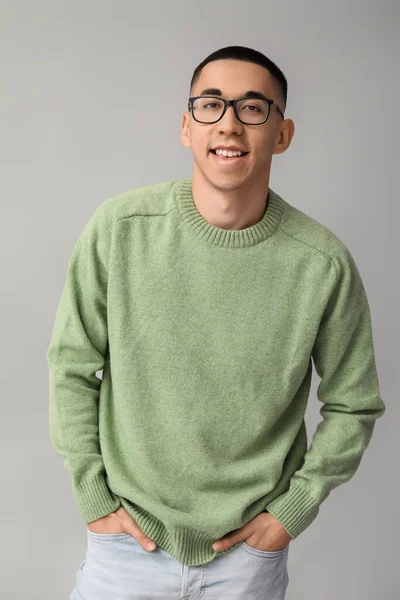身穿灰色背景针织毛衣的英俊年轻亚洲男子 — 图库照片