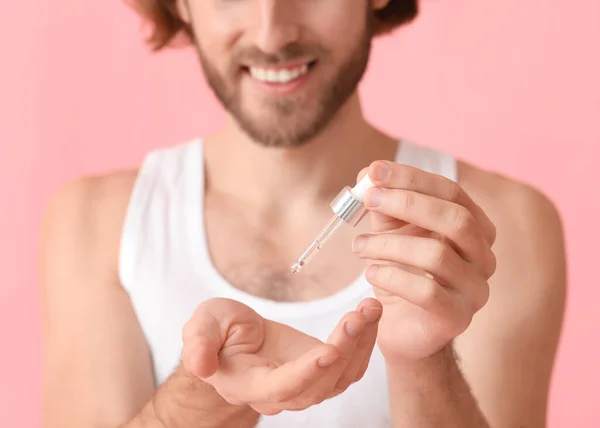 Hombre Joven Que Usa Suero Para Cuidado Piel Fondo Color —  Fotos de Stock