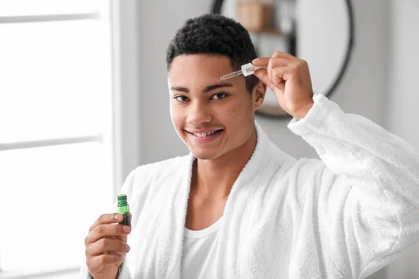 Young African American Guy Using Serum Skin Care Bathroom — Stock Photo, Image