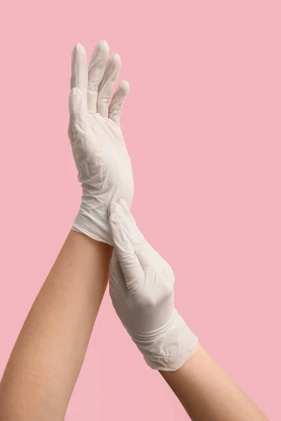 女性でホワイト医療手袋上のピンクの背景 — ストック写真