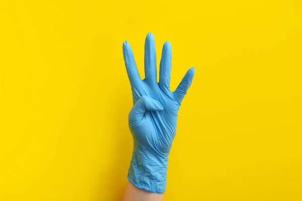 Woman Blue Medical Glove Showing Four Fingers Yellow Background — Stock Photo, Image