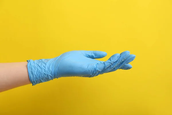 女性で青医療手袋上の黄色の背景 — ストック写真